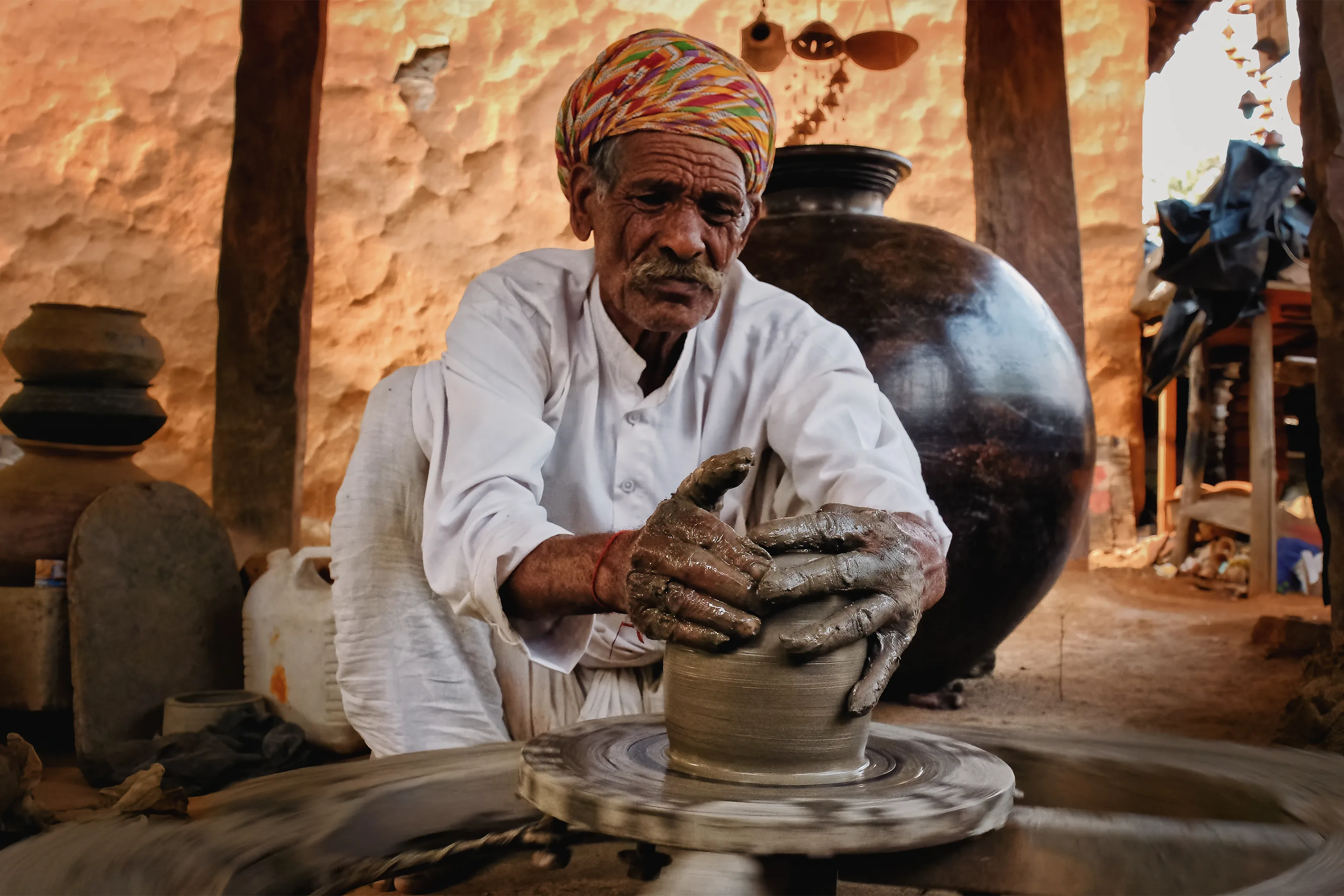 Local artisan shaping clay on a traditional pottery wheel